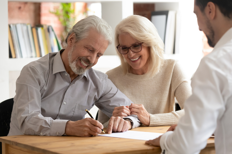 Happy older couple signing documents